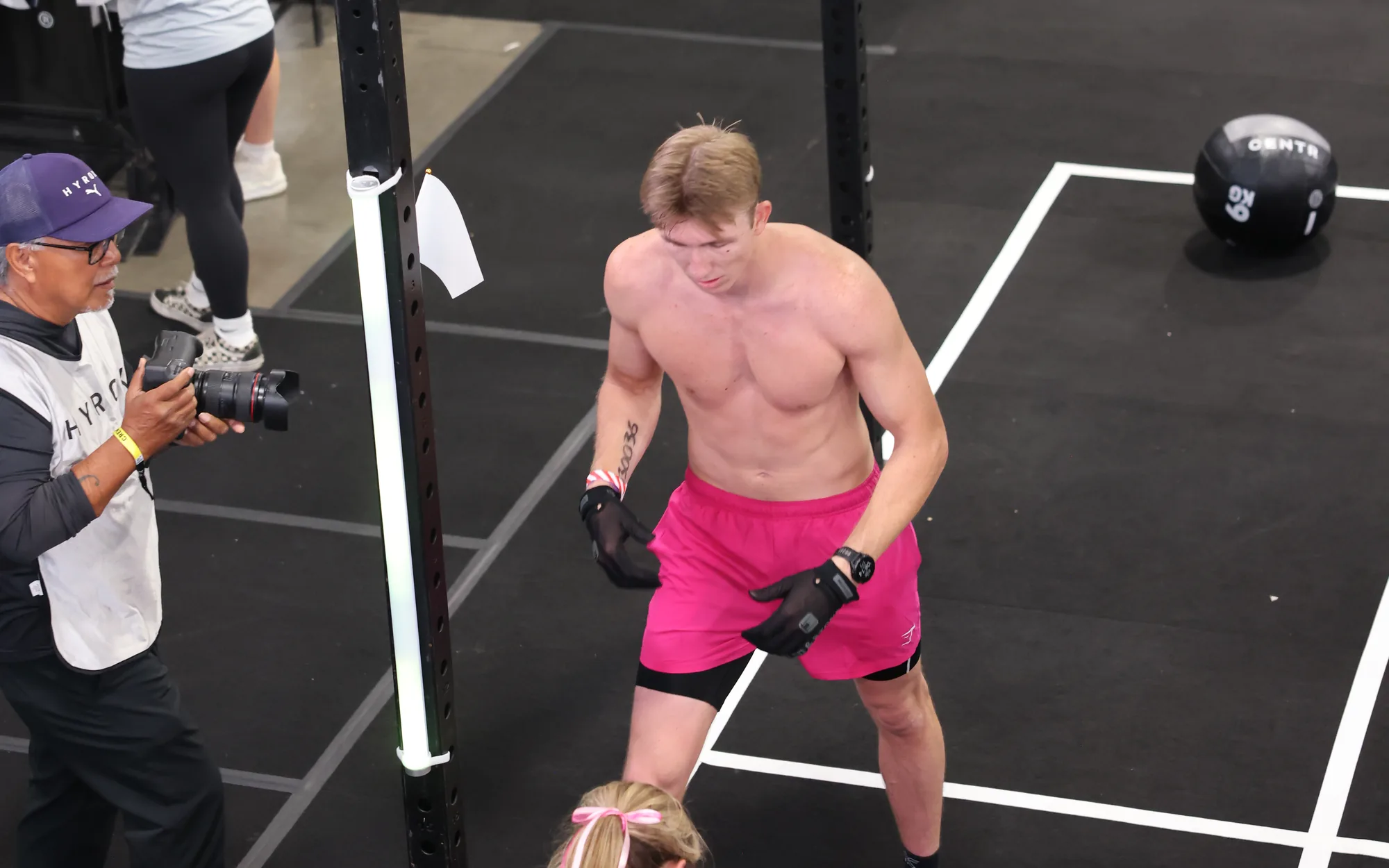 A racer in gloves at the wall ball station at HYROX Salt Lake City, seen from above, the target on the rig beside him