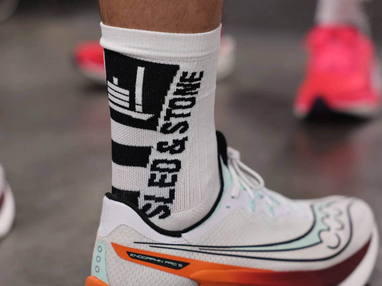 The Updraft race sock in white with black, Sled & Stone knitted down the cuff — view 2